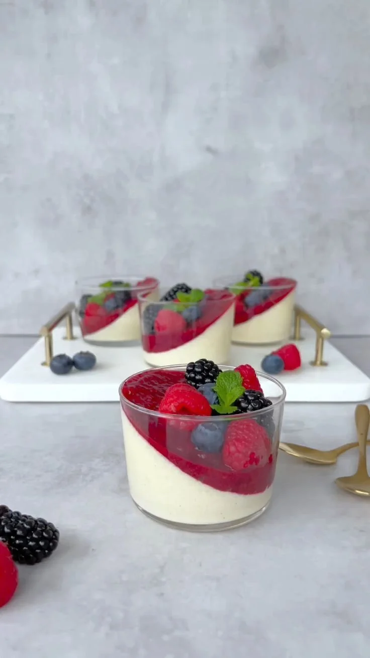 Delicious panna cotta dessert topped with fresh berries and mint leaves.