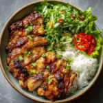 Delicious Vietnamese Lemongrass Chicken on a plate with herbs and rice